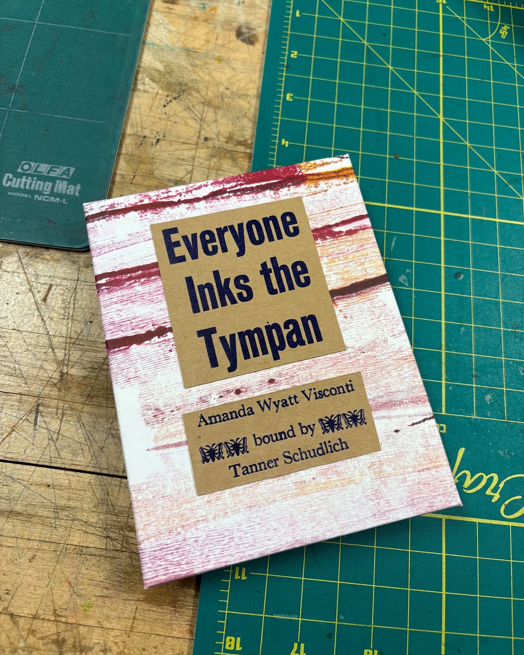 Photo of Tanner Schudlich of Stout Heart Press's hand binding of the tympan zine