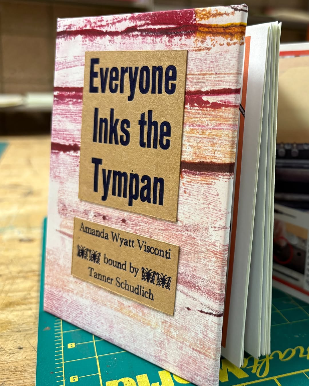 Photo of Tanner Schudlich of Stout Heart Press's hand binding of the tympan zine